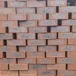 Country Classic Travertine Face Brick featuring rich ruby red colors with a deep blue-burnt flash, a rugged travertine finish, and weather-resistant rough edges.
