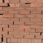 Blackwood Travertine Face Brick featuring a deep red clay color profile with mixed rugged tones, a travertine finish, and a consistent shape for budget-friendly building.