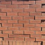 Redwood Travertine Flash Face Brick featuring a rich ruby red color profile with natural flash variations, a rugged travertine texture, and rustic rough edges.