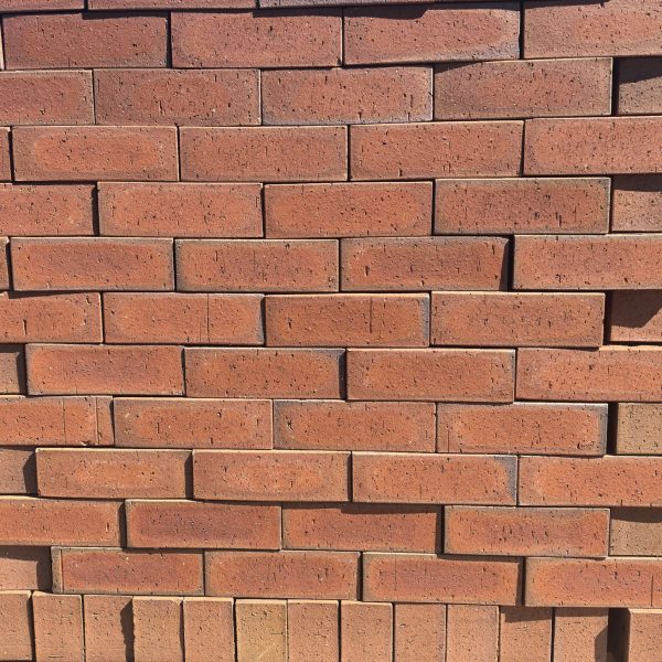 Redwood Travertine Flash Face Brick featuring a rich ruby red color profile with natural flash variations, a rugged travertine texture, and rustic rough edges.