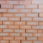 Front-on view of stacked Country Classic Satin face bricks showing rich red-terracotta clay body with prominent blue-grey to dark heat-flashed central cores and smooth satin texture.