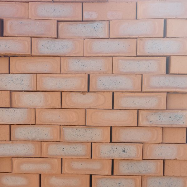 Front-on view of stacked Country Classic Satin face bricks showing rich red-terracotta clay body with prominent blue-grey to dark heat-flashed central cores and smooth satin texture.