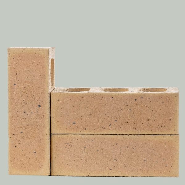 Studio arrangement of three Marble Satin face bricks with two stacked horizontally showing core holes and one standing vertically displaying iron spot speckling.
