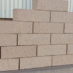 Outdoor pyramid stack of Pampas Satin face bricks displaying smooth satin surface finish, light wheat-tan clay body, and subtle iron speckling.