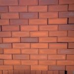 Redwood Satin Dark Face Brick featuring a dynamic mix of light ruby to dark red clay hues with a smooth satin finish for budget-friendly building projects.